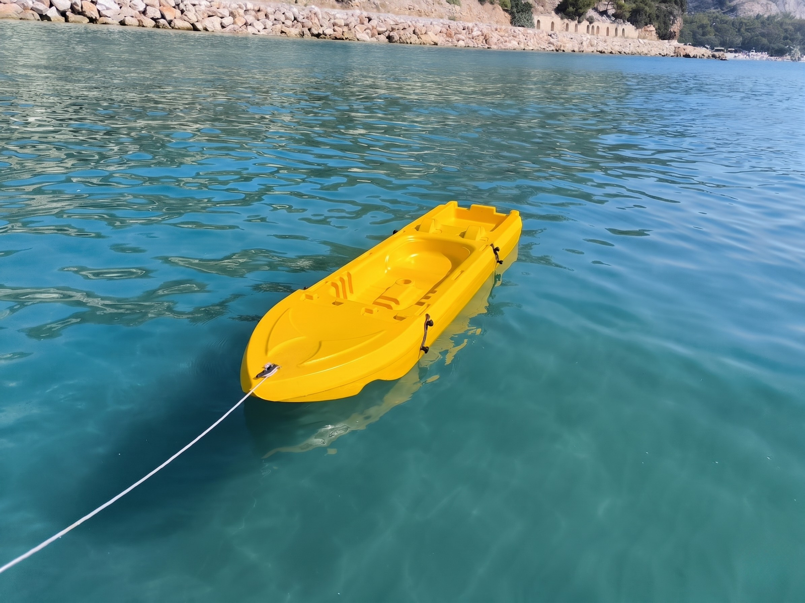 yellow joyn modular kayak on the water roped to boat